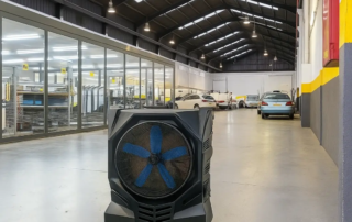 Climatizador evaporativo portátil funcionando en un taller mecánico abierto